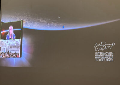 Presentation slide displaying Earth's horizon from space during a live virtual masterclass with NASA astronaut Dr. Karen Nyberg and Oxford Scholars students featuring the INTERWOVEN logo.