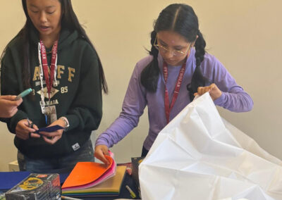 Oxford Scholars Programme students working with paper and white structural materials during the Moon habitat design challenge.