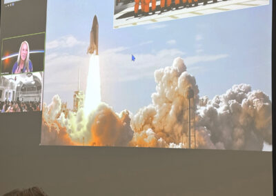 Presentation screen depicting a Space Shuttle launch and NASA astronaut crew during Dr. Karen Nyberg's student lecture.