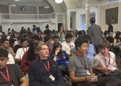 Students wearing scholar lanyards seated in a hall listening to an educational seminar during the Oxford Scholars Programme.